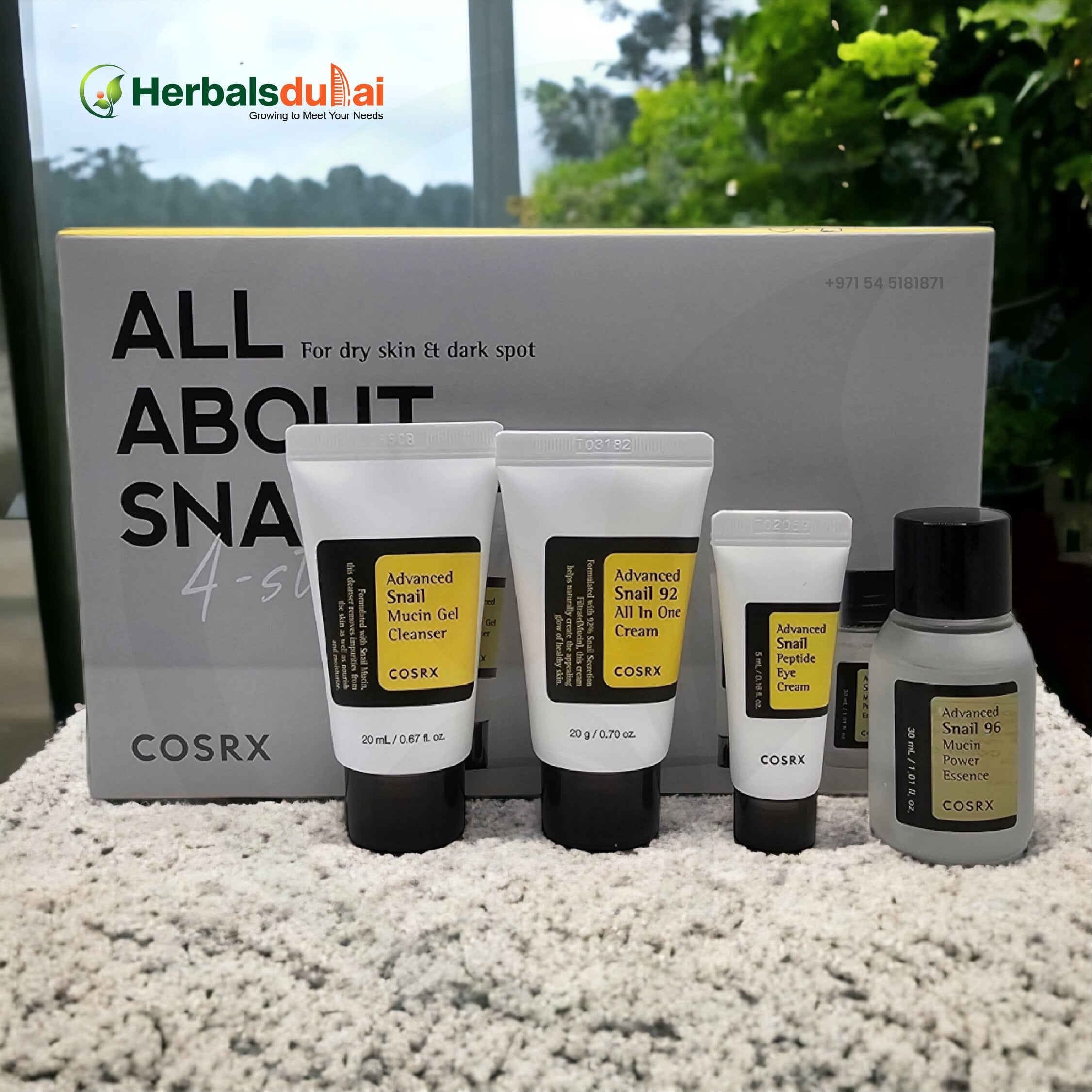 COSRX skincare products featuring Advanced Snail Mucin Gel Cleanser, Snail 92 All In One Cream, Snail Peptide Eye Cream, and Snail 96 Mucin Power Essence displayed on a textured surface with packaging in the background.