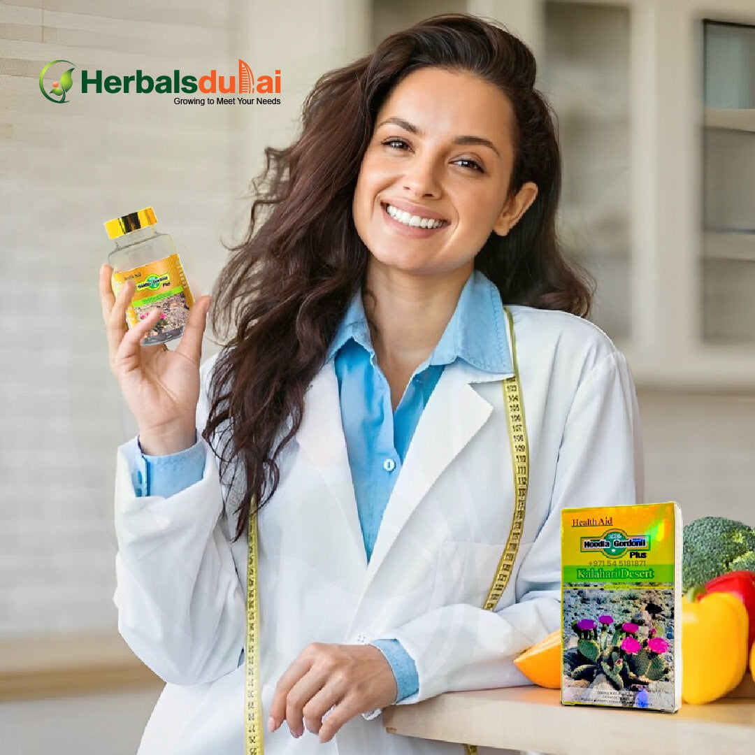 A woman in a white coat smiling and holding a jar of herbal products, standing beside boxes of natural supplements with healthy vegetables on a counter.